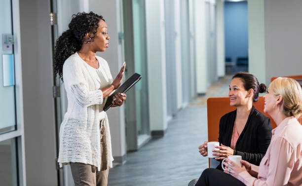 istock Multi-ethnic women in office drinking coffee, talking 1139565388