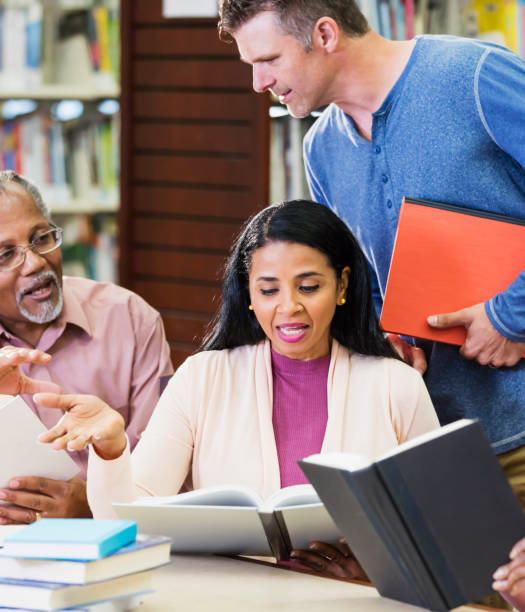 istock Diverse group of adult students conversing in library 1139566280