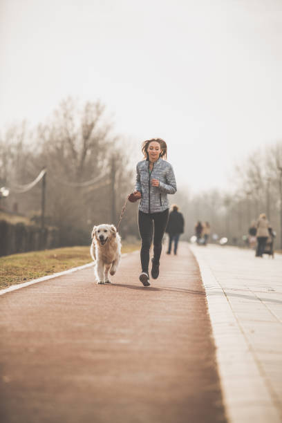 istock Young woman jogging with her dog 1139567444