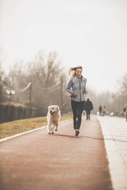istock Young woman jogging with her dog 1139567446