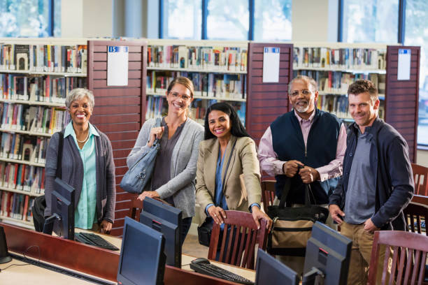 istock Multi-ethnic group of adults standing in library 1139567451