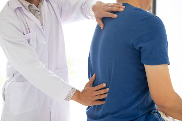istock Doctor physiotherapist treating lower back pain patient after while giving exercising treatment on stretching in the clinic, Rehabilitation physiotherapy concept 1139569549