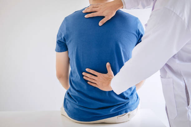 istock Doctor physiotherapist treating lower back pain patient after while giving exercising treatment on stretching in the clinic, Rehabilitation physiotherapy concept 1139569559