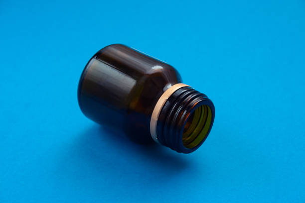 istock Empty glass dark bottle without pills on blue background. Medicines deficit concept. 1139569651
