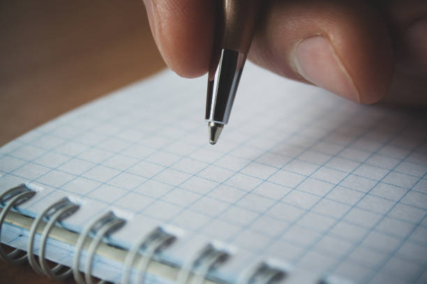 istock Pen and white notepad paper close up in man's hand 1139569673