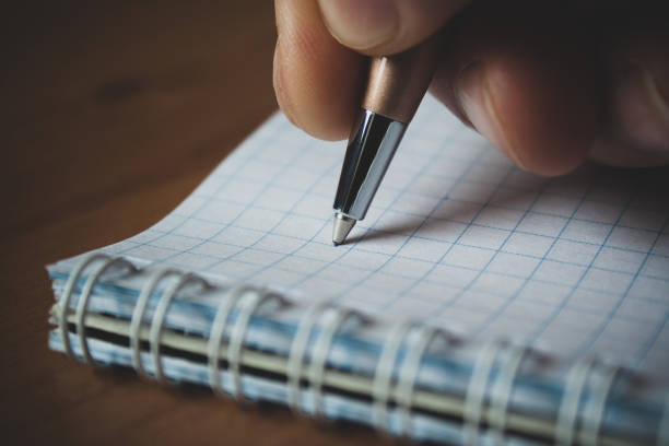 istock Pen and white notepad paper close up in man's hand 1139569674