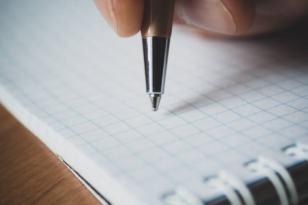 istock Pen and white notepad paper close up in man's hand 1139569710