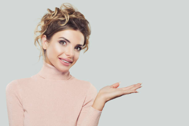 istock Happy Model Woman Holding Empty Open Hand with Copy Space and Smiling on White Background 1139570925