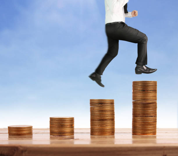 istock Businessman walk on stack of coins which grows success 1139579027