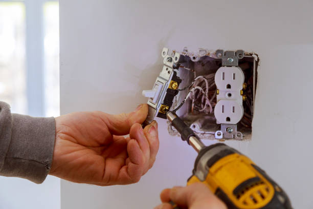 The hands of an electrician installing a power switch The hands of an electrician installing a power switch to the electrical junction box electrician stock pictures, royalty-free photos & images