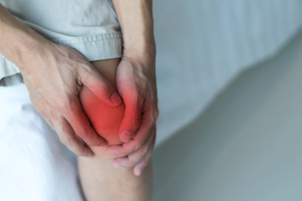 concepto de enfermedad del dolor de rodilla. las manos en la pierna como daño de la artritis, gota o infecciones. - cruciate ligament fotografías e imágenes de stock