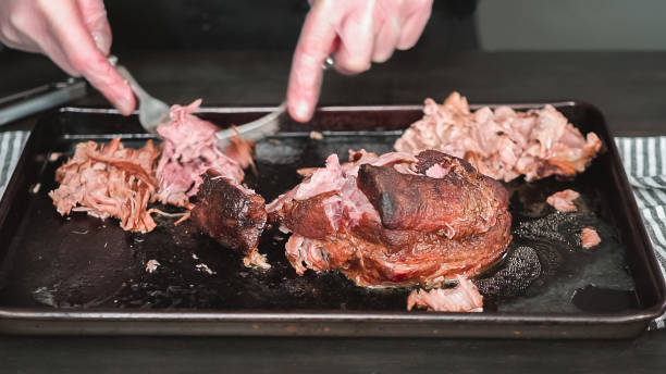 istock Shredding pork roast shoulder with two forks. 1139583386