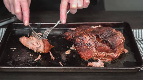 istock Shredding pork roast shoulder with two forks. 1139583397
