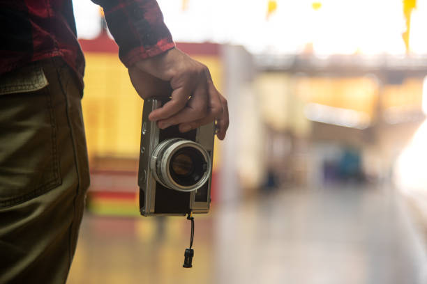 Tourist hand hold old style camera with blur background