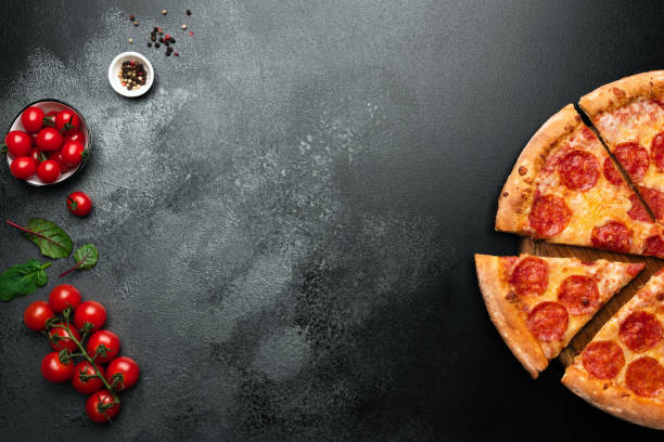pizza de pepperoni sobre fondo negro pizarra - pizza de chorizo fotos fotografías e imágenes de stock