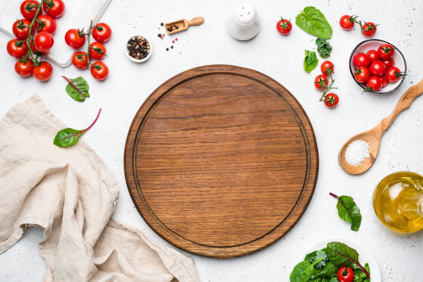 Wooden pizza board and pizza cooking ingredients Wooden pizza board and pizza cooking ingredients on white concrete background. Table top view. Copy space for text, recipe, restaurant or cafe menu ingredient stock pictures, royalty-free photos & images