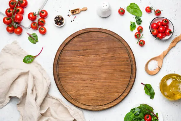 Photo of Wooden pizza board and pizza cooking ingredients