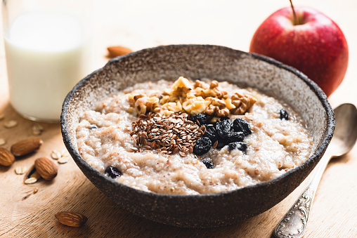 Breakfast porridge oats with seeds and raisins, closeup view. Healthy food