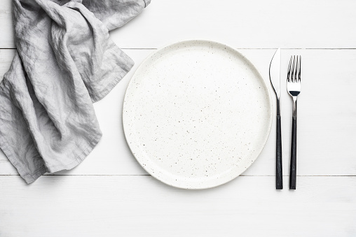 Empty plate, cutlery and linen textile. Table setting with copy space for text