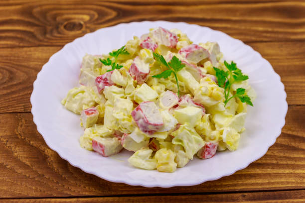 istock Salad with crab sticks, sweet corn, chinese cabbage, eggs and mayonnaise on wooden table 1139599009