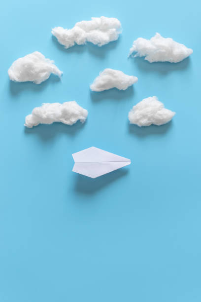 istock Paper origami plane among white clouds on blue background. 1139599041