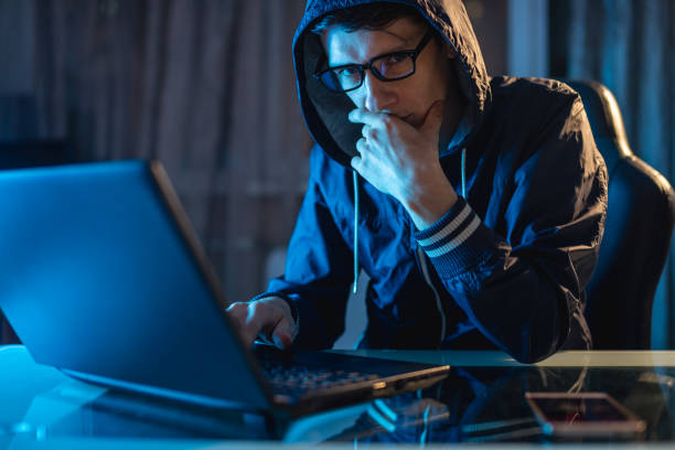 istock Male in the hood looking in the camera. Hacker attacks and stealing access databases with passwords. Cybersecurity 1139599104
