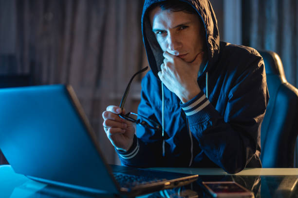 istock Male in the hood looking in the camera. Hacker attacks and stealing access databases with passwords. Cybersecurity 1139599110