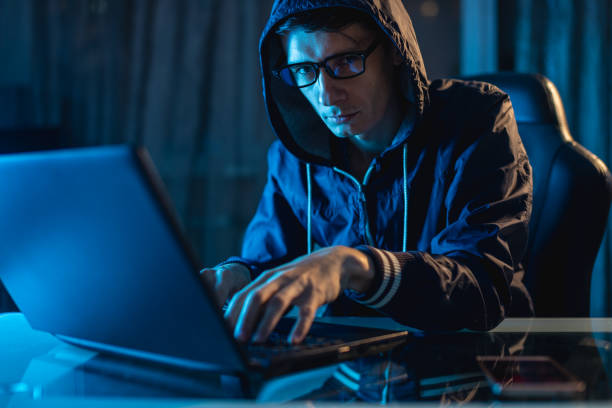 istock Male in the hood looking in the camera. Hacker attacks and stealing access databases with passwords. Cybersecurity 1139599114