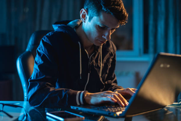 istock Young man worker working on a laptop at night. Freelancer designer or system administrator stayed late at work. 1139599125
