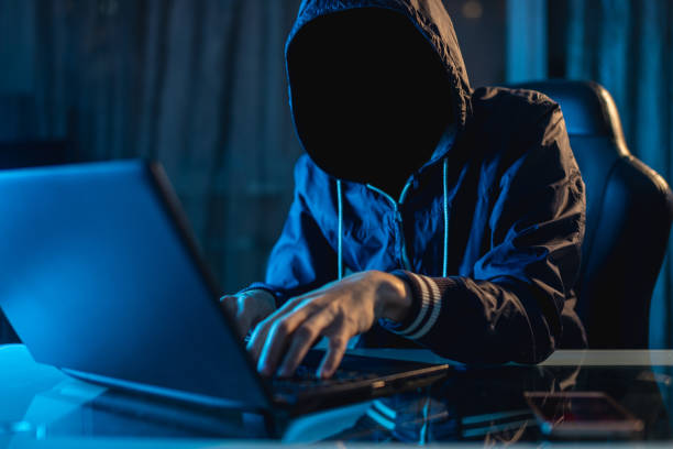 istock Anonymous hacker programmer uses a laptop to hack the system in the dark. Concept of cybercrime and hacking database 1139600296