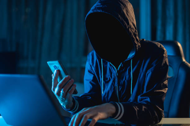istock Anonymous hacker programmer uses a laptop to hack the system in the dark. Concept of cybercrime and hacking database 1139600297