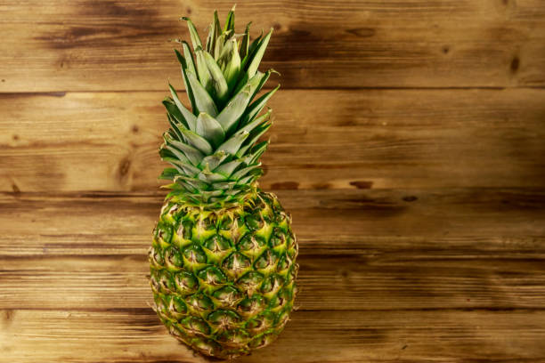 istock Whole pineapple on wooden table 1139603561