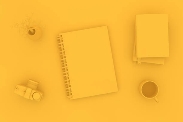 3d rendering of yellow color notebook with camera and books on yellow background. Office desktop, Workplace, Home Office.