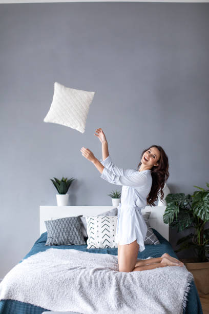 istock Beautiful cheerful woman with throws a pillow. 1139604689