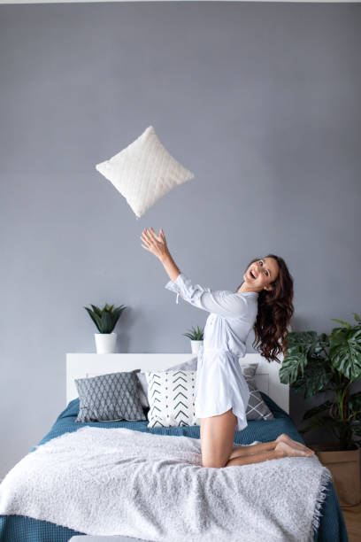 istock Beautiful cheerful woman with throws a pillow. 1139605021