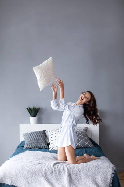 istock Happy woman with a pillow on weekend at home. 1139605620