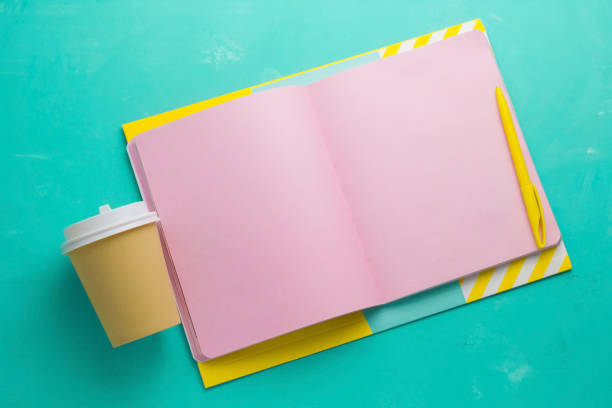 top view  mock up  open notepad with  blank pink paper sheetscoffee to go cup  a vibrant  blue background