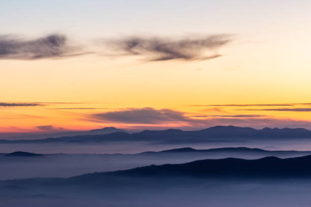 istock Beautifully colored sky at dusk, with mountains layers and mist between them 1139606917