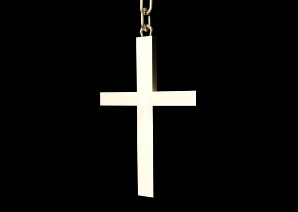 Golden 3D Christian cross on a chain hanging in the dark