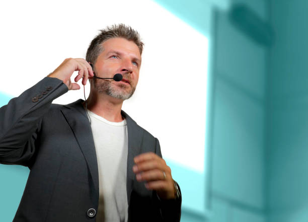 istock young attractive and confident successful man with headset speaking at corporate business coaching and training auditorium conference room talking giving motivation training from speaker stage 1139607992