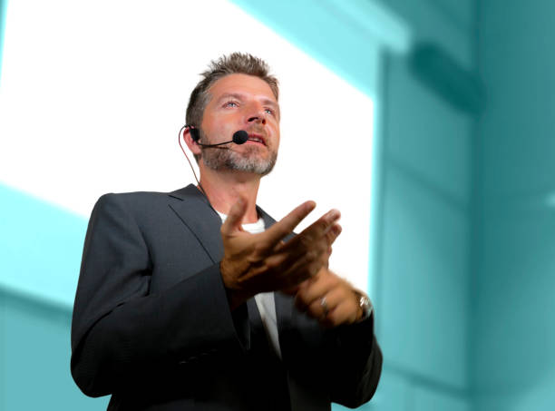 istock young attractive and confident successful man with headset speaking at corporate business coaching and training auditorium conference room talking giving motivation training from speaker stage 1139608048