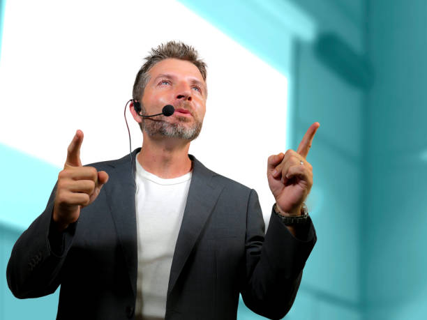 istock young attractive and confident successful man with headset speaking at corporate business coaching and training auditorium conference room talking giving motivation training from speaker stage 1139608072