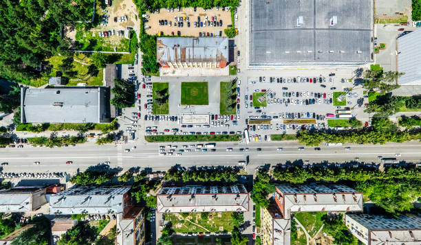 Aerial city view with crossroads and roads, houses, buildings, parks and parking lots. Sunny summer panoramic image - fotografia de stock