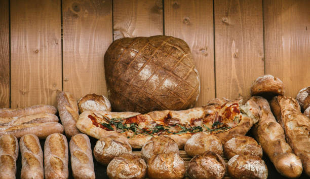 different fresh bread and pizza on the shelves in bakery. Selective focus