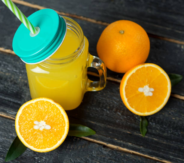 istock Fresh cold orange juice on dark wooden background 1139618692