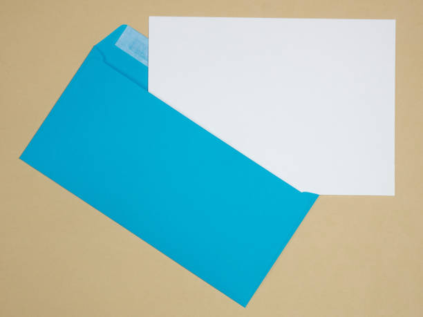 istock Blue envelope and white sheet of paper on a beige background 1139618800