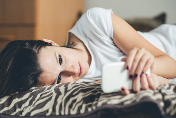 istock Woman lying on bed and using mobile phone. 1139619510