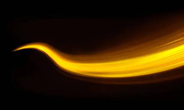 Photo of Glowing shiny curve light trail lines effect in black background.