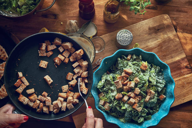 Preparing Cesar Salad with Chicken, Lettuce and Parmesan