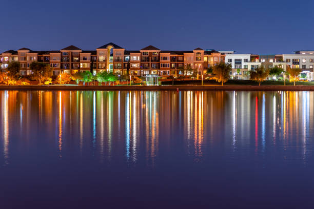 Trendy Lakefront Condos The multi-hued lights of stylish condos reflect off the calm waters of Tempe Town Lake in Tempe, Arizona. tempe arizona stock pictures, royalty-free photos & images